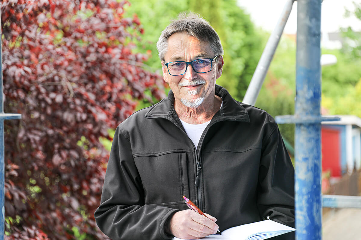 Michael Rheinfurth ist Sachverständiger in Dormagen und steht auf einem Baugerüst